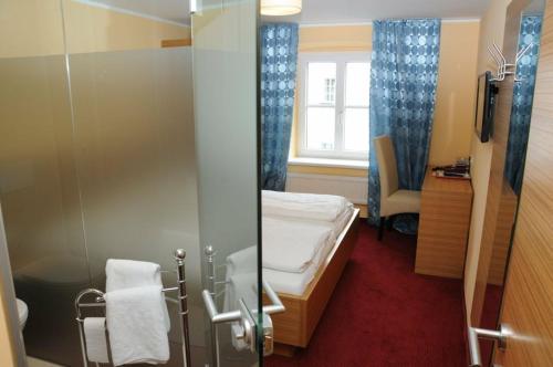 a small room with a bed and a window at Hotel Stiegenwirt in Schärding