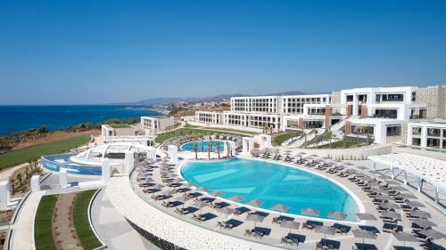 - une vue aérienne sur un complexe avec une piscine et des chaises dans l'établissement Mayia Exclusive Resort & Spa - Adults Only, à Kiotari