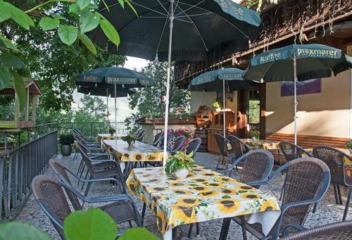 an outdoor patio with tables and chairs with umbrellas at Gasthof Jägerklause in Stummerberg