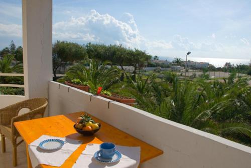 un tavolo con un cesto di frutta sul balcone di Alborea a Punta Braccetto