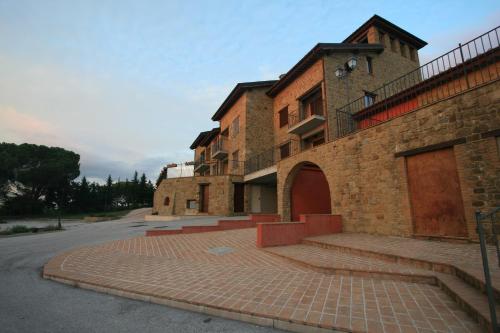 um antigo edifício de tijolos com um passeio de tijolos ao lado de uma rua em Case vacanze Villini panoramici sul Lago Trasimeno em Castel Rigone