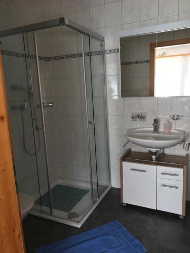 y baño con ducha y lavamanos. en Ferienwohnung Aquileia, en Scuol