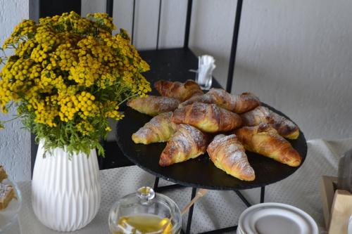 a plate of food on a table with a vase of flowers at Forest Retreat&Spa in Oveselu