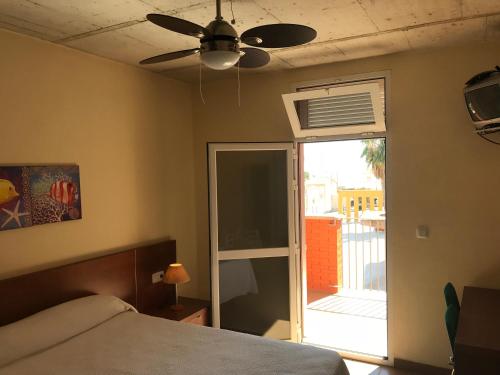um quarto com uma cama e uma ventoinha de tecto em Albergue De Puntas De Calnegre em Calnegre