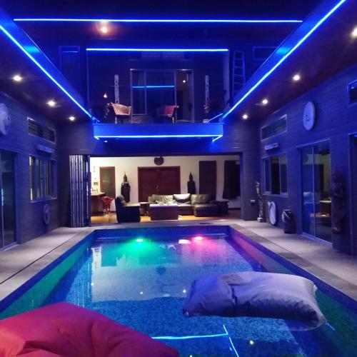 a swimming pool with blue lights in a house at Stunning villa with ocean views and free car in Lamai