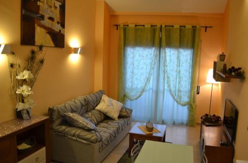 a living room with a couch in front of a window at Cal Ribero in Villanova de la Sal