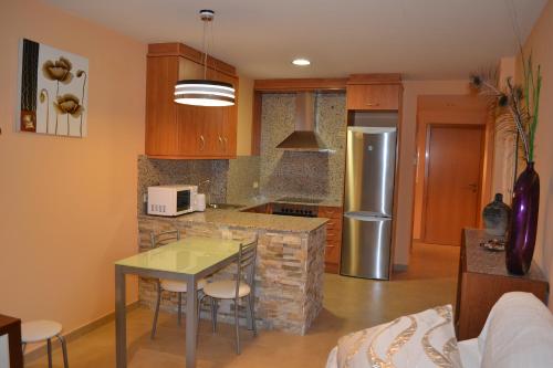 a kitchen with a table and a counter top at Cal Ribero in Villanova de la Sal