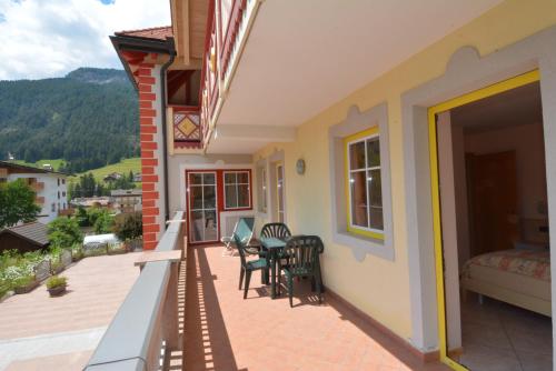 a balcony of a house with a bed and chairs at Casa Fior del Soreie in Pozza di Fassa