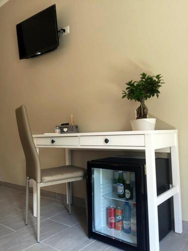 a white desk with a plant and a chair at Cosmo Rooms a pochi passi da Tropea in Tropea