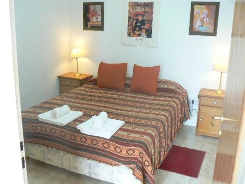 ein Schlafzimmer mit einem Bett mit zwei Handtüchern darauf in der Unterkunft Departamentos Santa Monica in Puerto Madryn