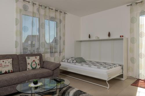 ein Wohnzimmer mit einem Bett und einem Sofa in der Unterkunft Ferienwohnung Bamberg in Bischberg