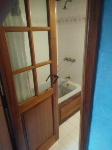 a door to a bathroom with a tub and a shower at Universal Traveller's Hostel in San Carlos de Bariloche