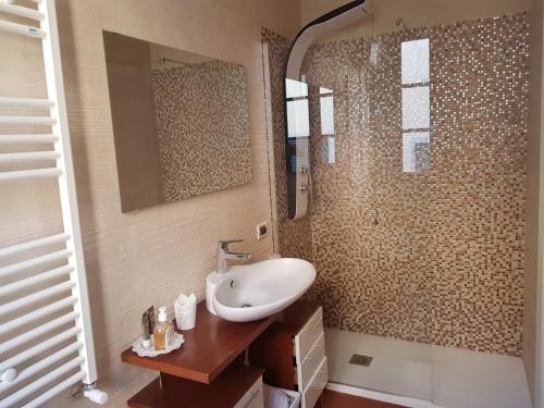ein Bad mit einem Waschbecken und einem Spiegel in der Unterkunft In Piazzetta in Pisa