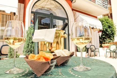 una mesa con dos copas de vino blanco y pan en Hotel Siviglia, en Fiuggi