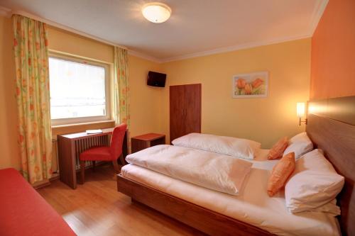 ein Hotelzimmer mit 2 Betten und einem Schreibtisch in der Unterkunft Hotel Ricci in Rust