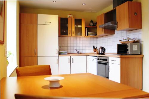 een keuken met witte kasten en een houten tafel bij Ferienwohnungen Schallenberg - Gross-Umstadt in Groß-Umstadt
