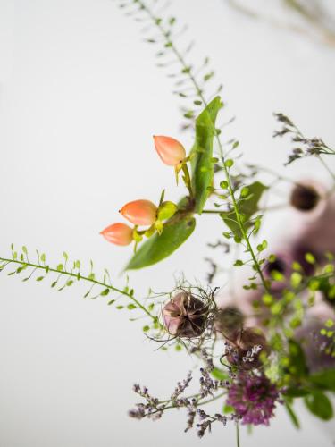 a vase of flowers with a person in the background at IMbery Hotel & Restaurant Hinterzarten in Hinterzarten