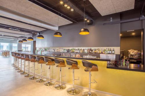 a bar with a row of stools in a restaurant at Planet Hotels ONE - Adults Only 16 years in El Arenal