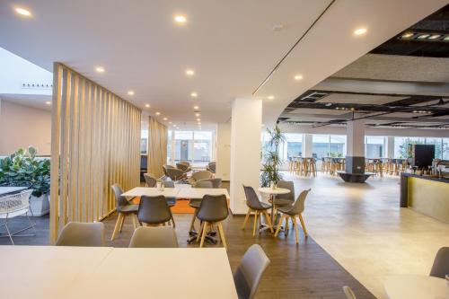 an office lobby with tables and chairs and a cafeteria at Planet Hotels ONE - Adults Only 16 years in El Arenal