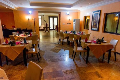 um restaurante com mesas e cadeiras num quarto em Clear Essence California Spa & Wellness Resort em Lagos