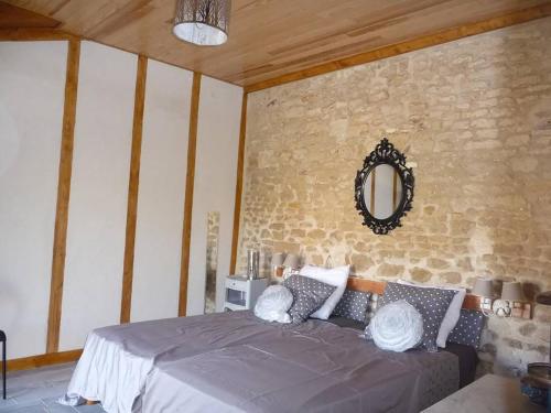 a bedroom with a bed and a mirror on the wall at Le Haut Fontaine : minis maisons de charme in Saint-Georges-lès-Baillargeaux