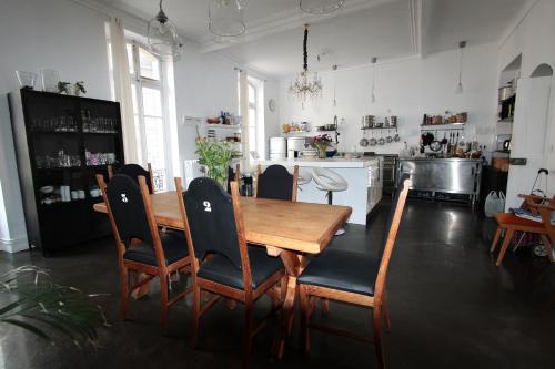 une cuisine avec une table et des chaises en bois dans l'établissement La maison d’arles, à Arles