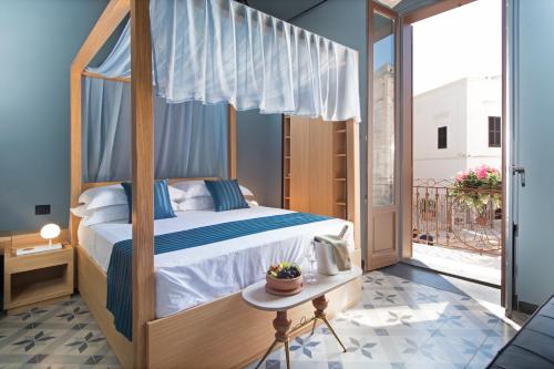 - une chambre avec un lit à baldaquin et un balcon dans l'établissement Sei Stelle Mama, à Polignano a Mare