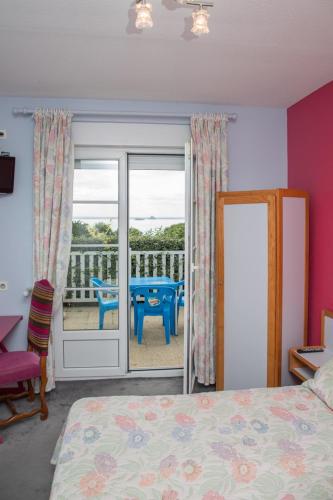 a bedroom with a bed and a balcony with a table at Les Hermelles in Champeaux