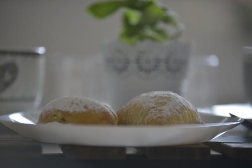 eine Platte mit drei Brotlaiben auf einem Tisch in der Unterkunft B & B Victoria in Pompei