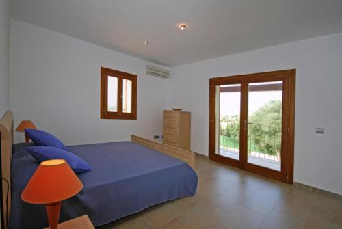 a bedroom with a blue bed and a window at Santa Maria in Alcudia
