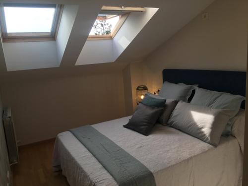 a bedroom with a large bed with two windows at Ático Jaca Ciudadela in Jaca