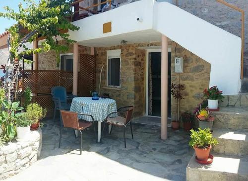 a patio with a table and chairs in front of a house at Spiros Apartments in Livadia