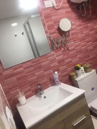 a bathroom with a sink and a mirror and a toilet at Sunny Apartment Puerto Rico in Puerto Rico de Gran Canaria