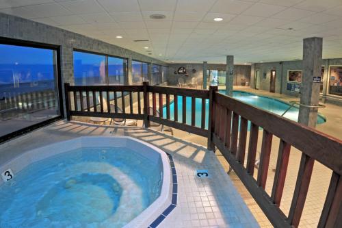 bañera de hidromasaje en el balcón de una casa en Promenade Inn & Suites Oceanfront en Seaside