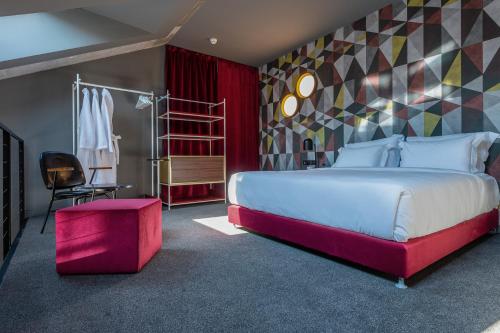 a bedroom with a large bed and a red stool at Stories Boutique Hotel in Budapest