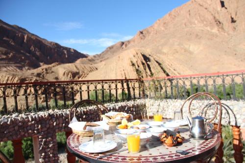 - une table avec de la nourriture et une vue sur la montagne dans l'établissement Maison d'Hôte Valentine, à Tinghir