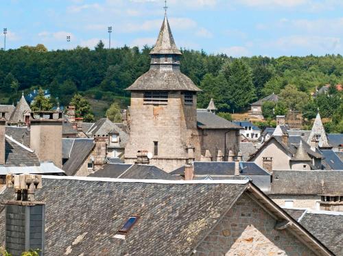 an old town with a tower on top of roofs at Auberge de la Tradition in Corrèze