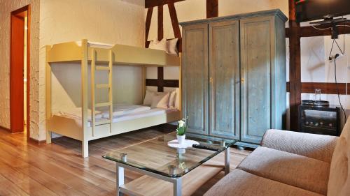 a living room with a bunk bed and a table at Hotel Restaurant Mönchhof in Gaggenau