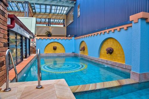 a large swimming pool in a building with a pool at Ettalong Beach Tourist Resort in Ettalong Beach
