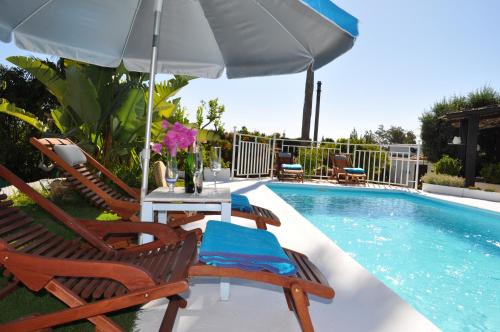 a swimming pool with two chairs and an umbrella at Casa Silca in Marbella
