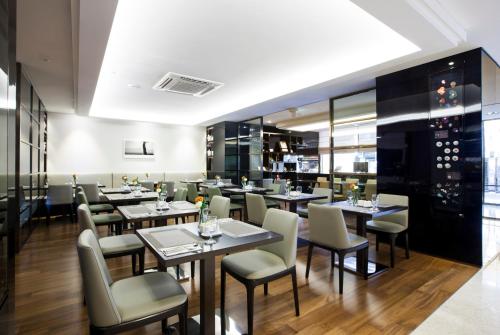 uma sala de jantar com mesas e cadeiras num restaurante em The Grand Hotel Myeongdong em Seul