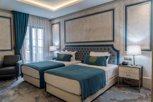 a hotel room with two beds and a chair at Mirart Hotel Boutique & SPA Yalova in Yalova