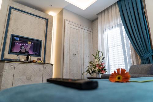 a room with a television and a table with flowers at Mirart Hotel Boutique & SPA Yalova in Yalova