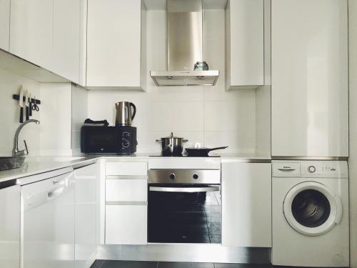 uma cozinha branca com um fogão e uma máquina de lavar roupa em New apartment in San Juan Playa, Alicante em Alicante