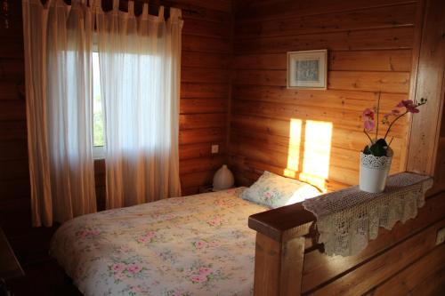 una camera con un letto in una baita di tronchi di Ananda a Hararit