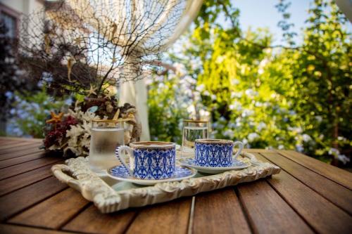 two blue and white cups and saucers on a wooden table at Cunda Esen Hotel in Ayvalık