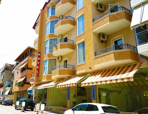 un edificio alto con macchine parcheggiate di fronte di Hotel Veli a Sarandë