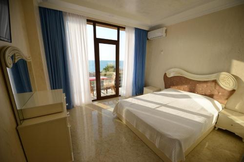 a bedroom with a bed and a window and a television at Medea Kvariati in Kvariati