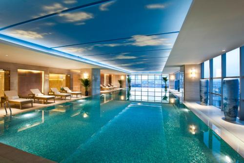 a large swimming pool in a hotel lobby at Wanda Realm Langfang in Langfang