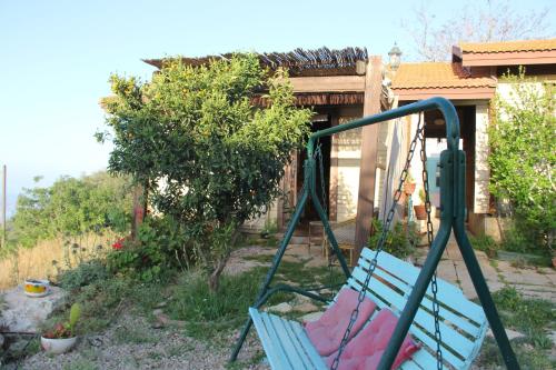 a blue swing in a yard with a house at Ananda in Hararit